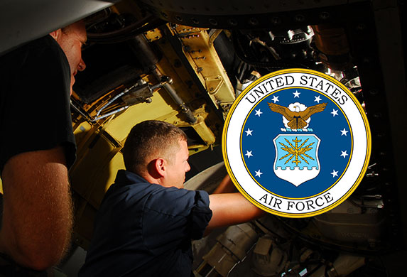 An aircraft maintainer working on a jet with the image of the Air Force logo